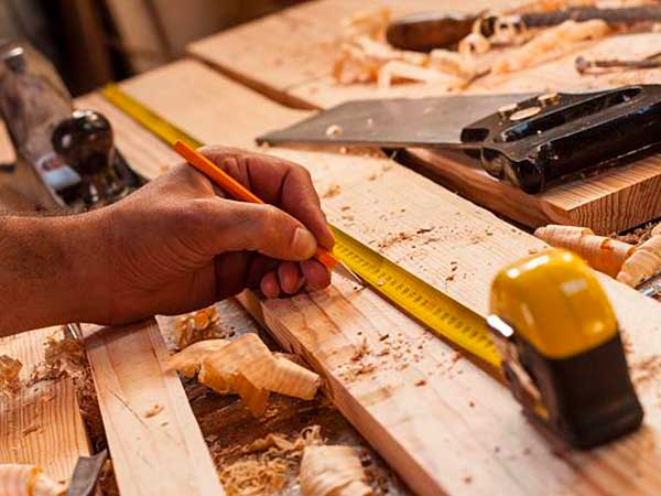 carpenter taking measurement Lavorazione-artigianale